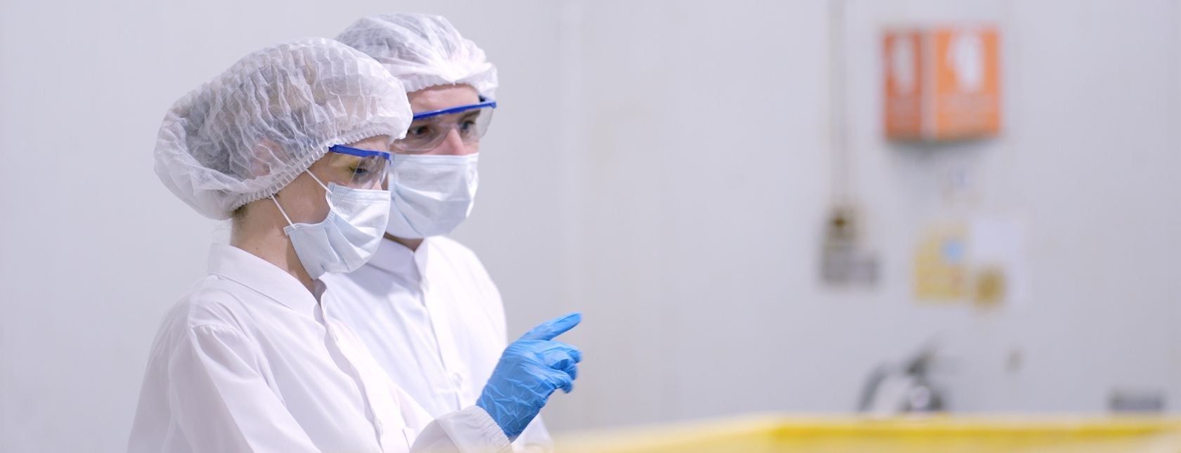 Productiemedewerkers in witte, steriele uniformen voorkomen besmetting