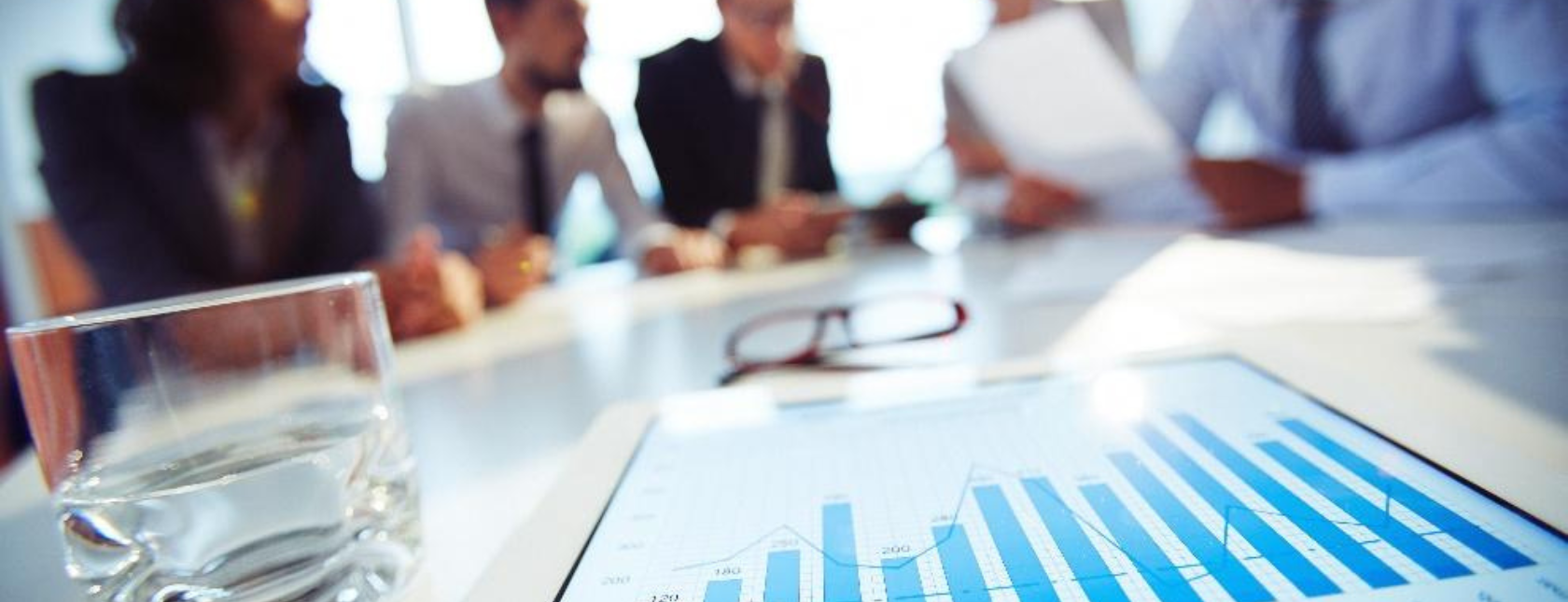 Groep collega's discussieren aan tafel over rapportages.