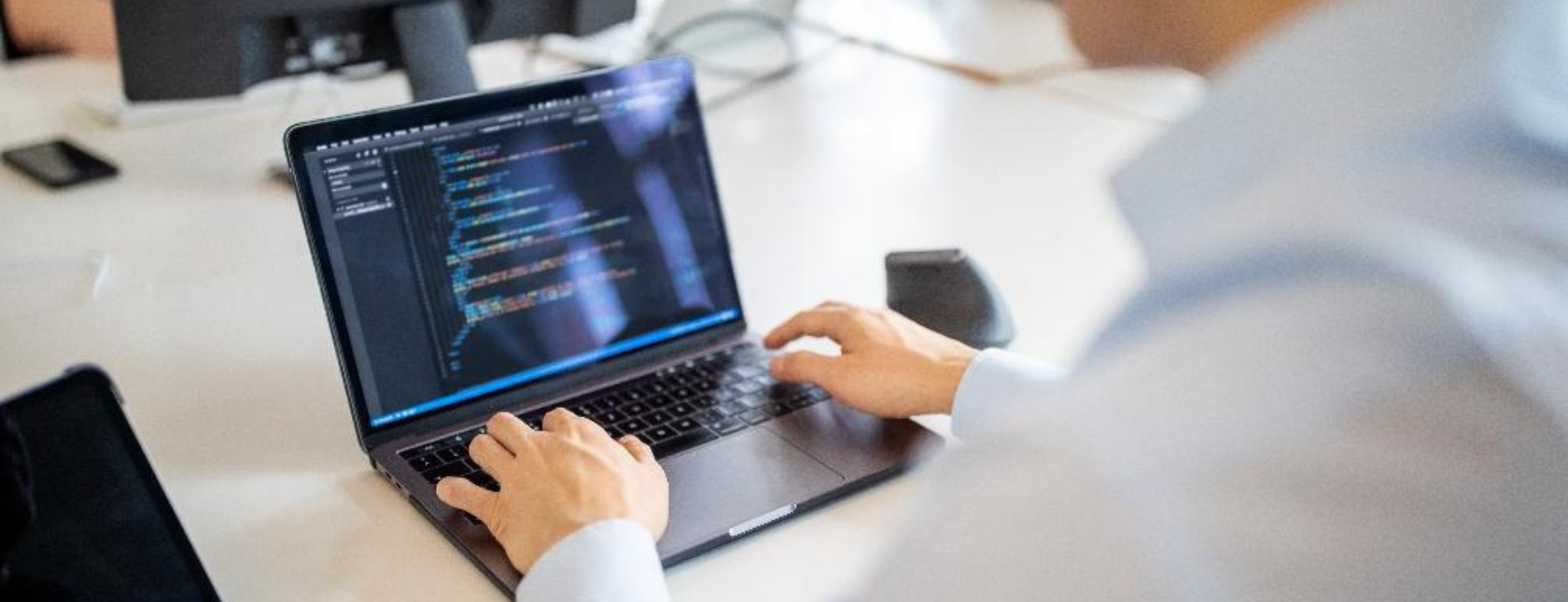 Man die op zijn werkplek aan een laptop werkt