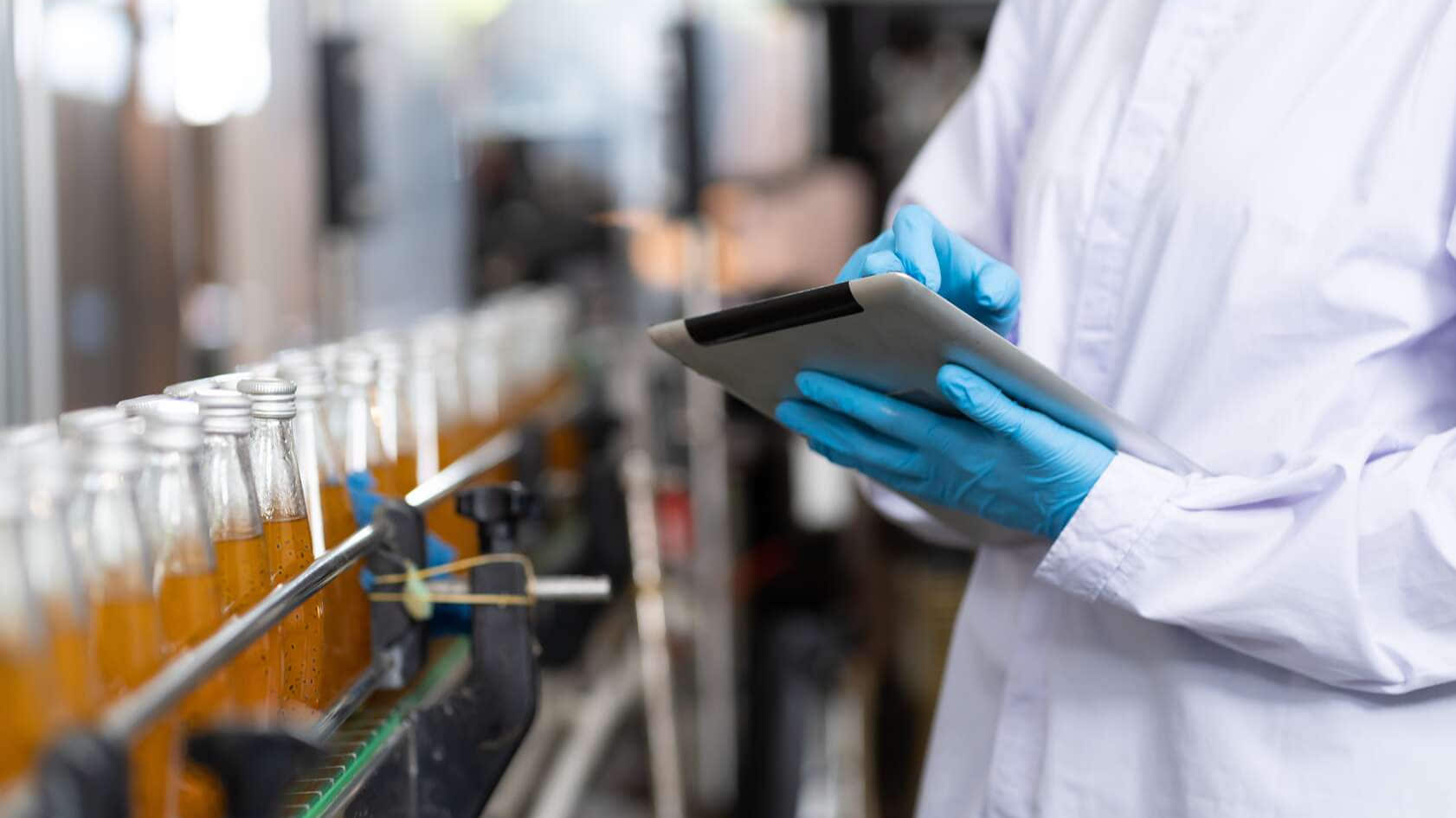 Persoon met een tablet in de hand voor een drankvulstation
