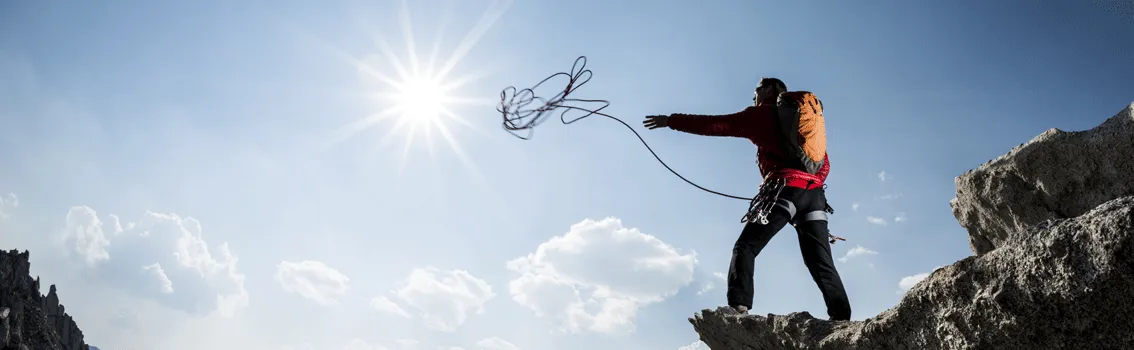 Mountain climber throwing a rope
